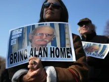 Supporters hold signs Dec. 3, 2013 in support of imprisoned U.S. citizen Alan Gross. He was released from a Cuban prison Dec. 17, 2014. 