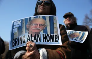 Supporters hold signs Dec. 3, 2013 in support of imprisoned U.S. citizen Alan Gross. He was released from a Cuban prison Dec. 17, 2014.   Alex Wong/Getty Images.