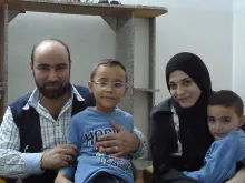 Syrian refugee and Caritas Jordan volunteer Amer Fahd Al Naser, his wife Noor and their sons at their apartment in Jordan, Oct. 27, 2014.