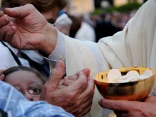 The Eucharist is distributed during Mass with Pope Francis in Rome's Campo Verano cemetery for All Saints Day on Nov. 1, 2013. 