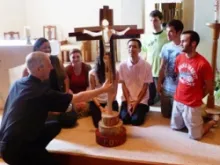 The Olympic Cross being blessed by Fr. Simon, with youth leaders from the Joshua Camp. 
