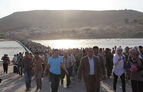 Thousands of Syrians streamed across a bridge over the Tigris River, entering Iraq on Thursday, August 15, 2013. ?w=200&h=150