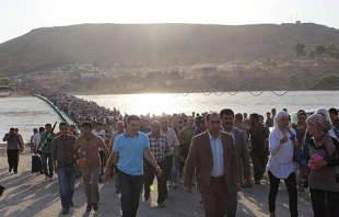 Thousands of Syrians streamed across a bridge over the Tigris River, entering Iraq on Thursday, August 15, 2013.   UNHCR/G.Gubaeva.
