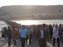 Thousands of Syrians streamed across a bridge over the Tigris River, entering Iraq on Thursday, August 15, 2013. 