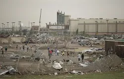 People walk through a damaged area near the Moore Warren Theater after a powerful tornado ripped through the area on May 20, 2013 in Moore, OK. ?w=200&h=150