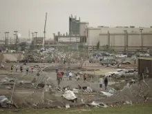 People walk through a damaged area near the Moore Warren Theater after a powerful tornado ripped through the area on May 20, 2013 in Moore, OK. 