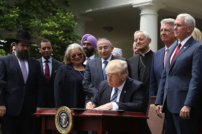 US President Donald Trump is flanked by clergy members as he signs an Executive Order on Promoting Free Speech and Religious Liberty May 4 2017 Credit Mark Wilson Getty Images CNA