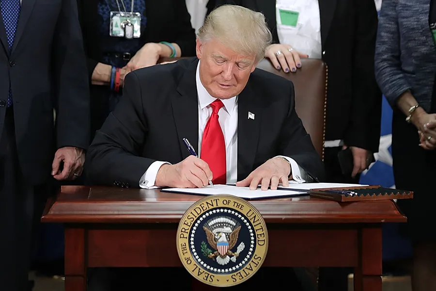U.S. President Donald Trump signs two executive orders during a visit to the Department of Homeland Security. ?w=200&h=150
