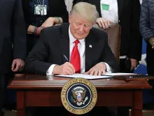 U.S. President Donald Trump signs two executive orders during a visit to the Department of Homeland Security. 