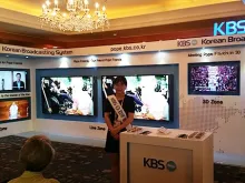 University student Sun-Joo Pae assists international press at the KBS stand inside the media center at the Lotte Hotel in Seoul, South Korea. 