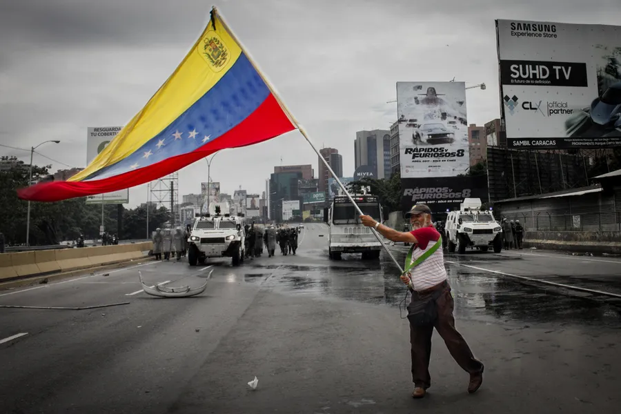 May 3, 2017 Deputy of the National Assembly holds a Venezuelan flag when the protest in Caracas is repressed by the Bolivarian National Guard with tear gas. Credit: Reynaldo Riobueno/Shutterstock?w=200&h=150