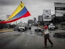 May 3, 2017 Deputy of the National Assembly holds a Venezuelan flag when the protest in Caracas is repressed by the Bolivarian National Guard with tear gas. Credit: Reynaldo Riobueno/Shutterstock