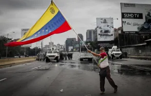 May 3, 2017 Deputy of the National Assembly holds a Venezuelan flag when the protest in Caracas is repressed by the Bolivarian National Guard with tear gas. Credit: Reynaldo Riobueno/Shutterstock 