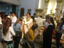 Vietnamese youth receiving a blessing and Easter eggs following the Mass at Chair of St. Peter parish in Bangkok, April 20, 2014. 