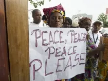 Women carry placards with messages of peace during a UN visit in the Democratic Republic of the Congo on May 23, 2013. 