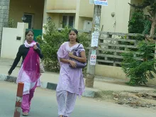 Young professional women walk along the street in Bangalore, India. 