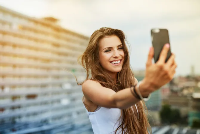 Young woman smart phone Millennial selfie Credit baranq Shutterstock CNA