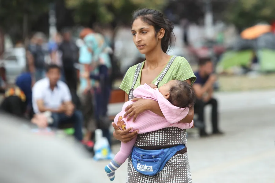 A young woman waits with her child by the train station in Belgrade, Serbia. ?w=200&h=150