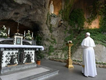 Pope Francis prays at the Lourdes Grotto in the Vatican Gardens May 30, 2020.