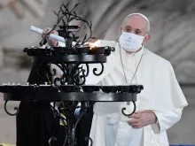 Pope Francis light a candle during an interreligious ceremony in the Campidoglio Square, Rome, Oct. 20, 2020. 