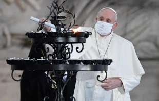 Pope Francis light a candle during an interreligious ceremony in the Campidoglio Square, Rome, Oct. 20, 2020.