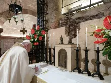 Pope Francis signs his new encyclical, Fratelli tutti, on the altar before the tomb of St. Francis of Assisi on Oct. 3, 2020. Photo 