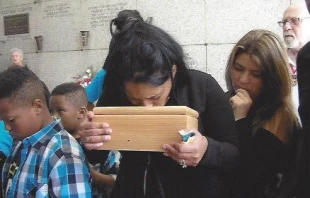 A family grieves their lost baby at a funeral at the crypt at St. Patrick’s Cemetery in New Orleans. Many friends, relatives, and families attended the funeral that day. Credit: Photo courtesy of Compassionate Burials for Indigent Babies