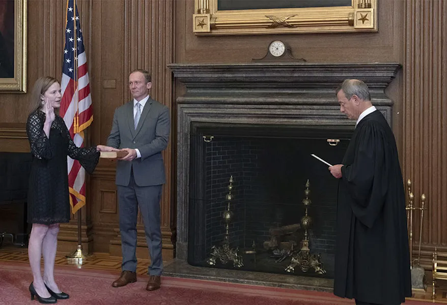 Chief Justice John G. Roberts administers the Judicial Oath to Judge Amy Coney Barrett in the Supreme Court Building. Barrett's husband Jesse holds the Bible. ?w=200&h=150