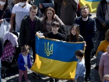 A group of people in St. Peter's Square hold a Ukrainian flag during Pope Francis' Angelus on Sunday, March 20, in Vatican City.