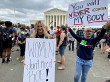 Anna Lulis from Moneta, Virginia, (left) who works for the pro-life group Students for Life of America, stands beside an abortion rights demonstrator outside the U.S. Supreme Court in Washington, D.C., on June 24, 2022, after the court's decision in the Dobbs abortion case was announced.