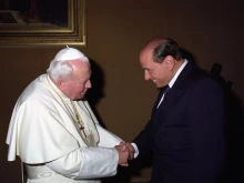 St. Pope John Paul II greets former Italian Prime Minister Silvio Berlusconi.