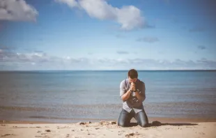 Man kneeling at beach /   Ben White on Unsplash