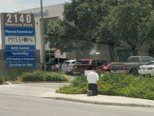Bishop Emeritus Michael Pfeifer of San Angelo, Texas, prays in front of a Planned Parenthood facility.