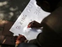 A man makes a sign outside the Permanent Mission of Nigeria to the United Nations on June 2, 2014 in New York City. 