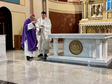 Bishop Robert Brennan blesses the altar at Annunciation of the Blessed Virgin Mary Church in Brooklyn, New York, with holy water on Nov. 4, 2023, in response to the filming of an indecent music video in the church. Assisting the bishop is Monsignor Joseph Grimaldi, vicar general of the Diocese of Brooklyn.