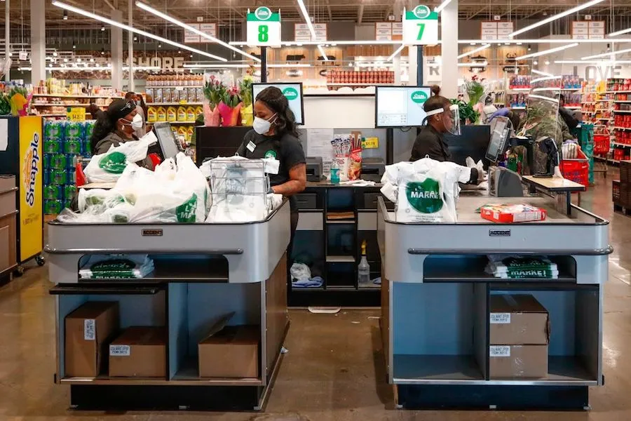 Cashiers ring up groceries for customers at the Local Market Foods store in Chicago, Illinois, on April 8, 2020. ?w=200&h=150