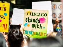 A protest against Immigration and Customs Enforcement features a sign that reads “Chicago Stands With Immigrant Families.”  The Department of Homeland Security denies ICE targeted a Chicago parish on Oct. 12, 2025.
