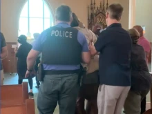 Pro-abortion protesters are escorted from Mass at St. Joseph Catholic Church in Chicago, June 26, 2022.