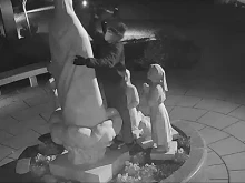 Surveillance footage shows a man hammering at the Our Lady of Fatima statue located outside the Basilica of the National Shrine of the Immaculate Conception in Washington, D.C., on Dec. 5, 2021.
