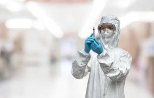 A lab technician scientist in PPE.   Chinnapong / Shutterstock.