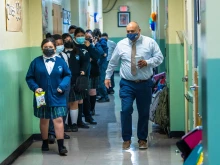 Students walk in a line with a teacher in Dolores Mission School in Boyle Heights, Los Angeles.