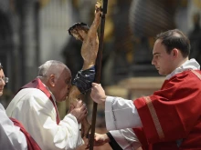 Pope Francis kisses the crucifix at the Liturgy of the Lord's Passion in St. Peter's Basilica on April 7, 2023.