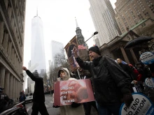 Michael Phelps of Good Counsel Homes prays the rosary with others as they pass Trinity Church in the shadow of the Freedom Tower in Lower Manhattan on March 25, 2023.