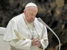 Pope Francis prays at his general audience Dec. 20, 2023, in Paul VI Hall at the Vatican.