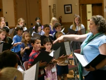 Mary Ann Wilson conducts a children’s choir during Mass at St. Thomas the Apostle Parish in Ann Arbor, Michigan.