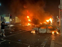 Flames rise from the car and a bus, set alight at the junction of Bachelors Walk and the O'Connell Bridge, in Dublin on Nov. 23, 2023, as people took to the streets following the stabbings earlier in the day.
