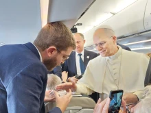Pope Leo XIV blesses rosaries for EWTN News’ Elias Turk aboard the papal plane to Ankara, Turkey, on Nov. 27, 2025.