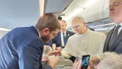 Pope Leo XIV blesses rosaries for EWTN News' Elias Turk aboard the papal plane to Ankara, Turkey, on Nov. 27, 2025.
