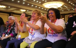 Carmen Ciriaco and Dr. Perla Indarte of Brooklyn, and Mayra Reyes of Santa Fe cheer during a V Encuentro session.   Mary Rezac/CNA
