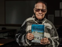 Fr. Richard Cassidy, professor of Sacred Scripture at Sacred Heart Major Seminary, dresses in Roman prisoner garb as he holds a copy of his newest book, "A Roman Commentary on St. Paul’s Letter to the Philippians." Fr. Cassidy's eighth scholarly work, the book explores the subversive nature of St. Paul's Letter to the Philippians, which the apostle wrote from behind bars in a Roman prison cell.